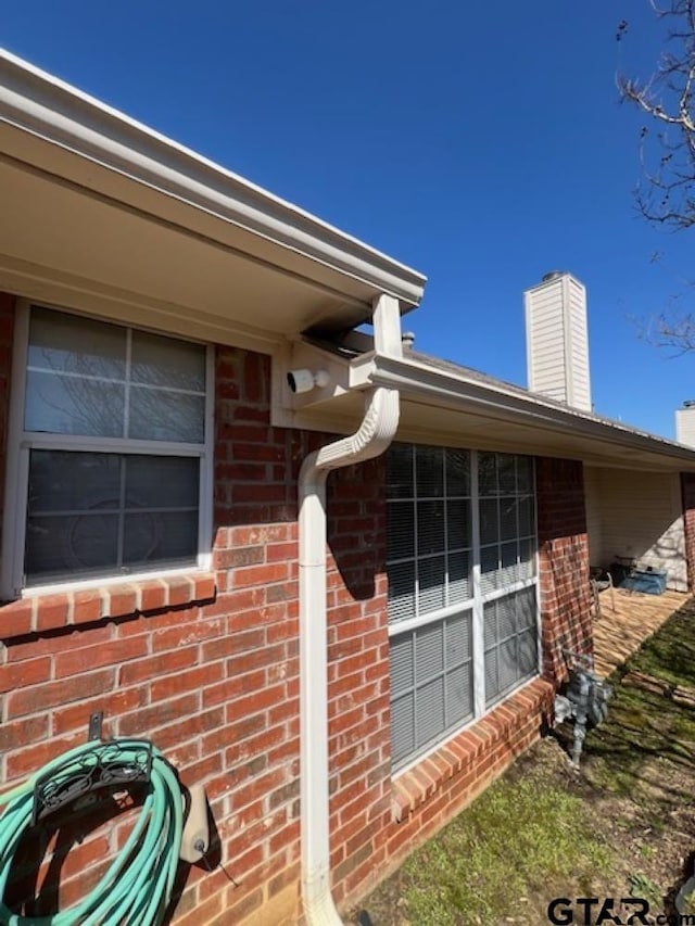 exterior details featuring gas meter and brick siding