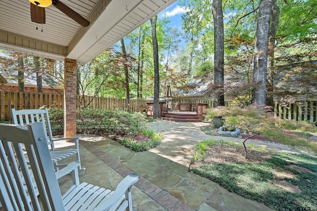 view of patio / terrace featuring a deck, fence, and ceiling fan