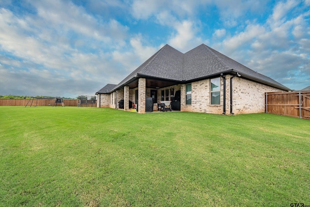 213 Serenity Dr, Bullard, TX 75757 - rear view of house with brick siding, a fenced backyard, and roof with shingles