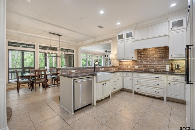kitchen with a sink, decorative backsplash, light tile patterned floors, and dishwasher