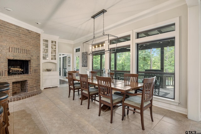 dining space featuring crown molding, built in features, a brick fireplace, and light tile patterned floors