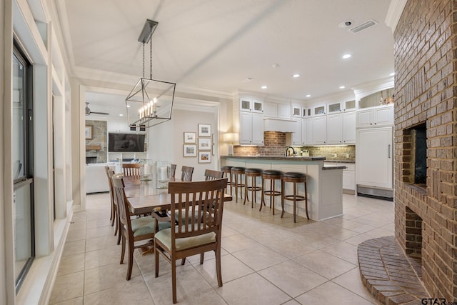 dining area with visible vents, crown molding, recessed lighting, a large fireplace, and light tile patterned floors
