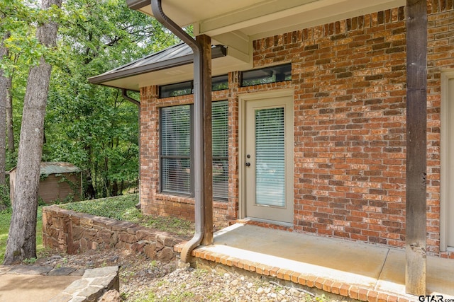 property entrance featuring brick siding