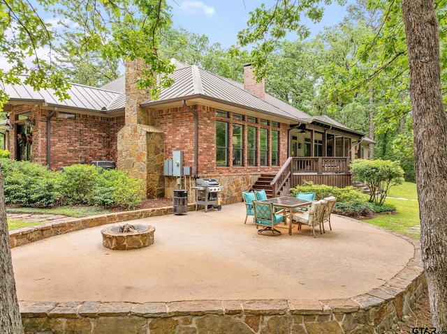 view of patio featuring a ceiling fan, a fire pit, a deck, and area for grilling