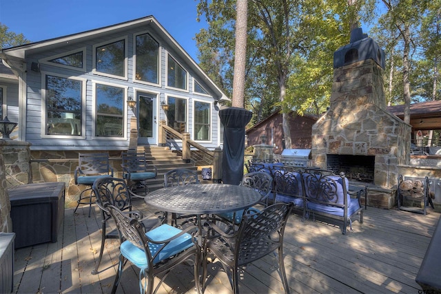 wooden deck featuring a grill and an outdoor stone fireplace