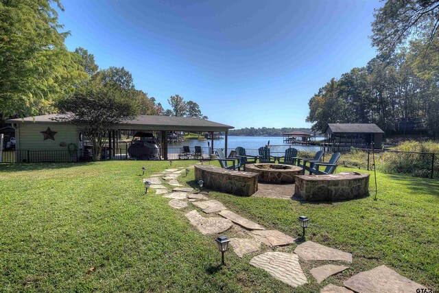 view of yard with a gazebo, a water view, and a fire pit