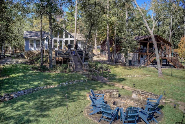 view of yard with a wooden deck and an outdoor fire pit