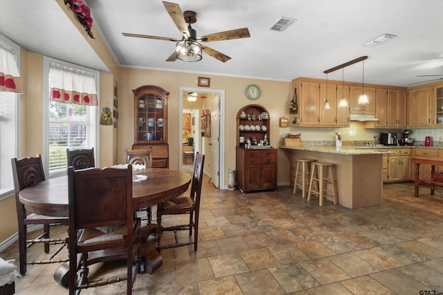 dining room with ceiling fan and crown molding