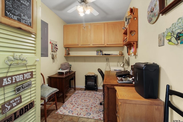 office with electric panel, a wood stove, and ceiling fan