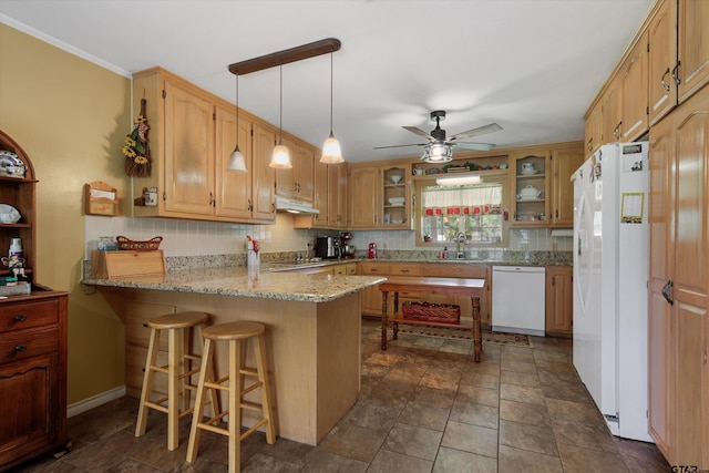 kitchen with white appliances, a breakfast bar area, sink, and kitchen peninsula