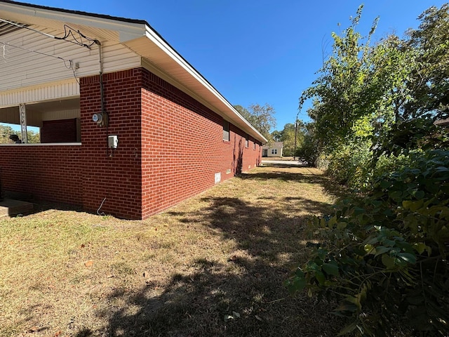 view of side of home with a lawn