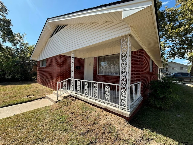 view of front of house with a porch and a front lawn