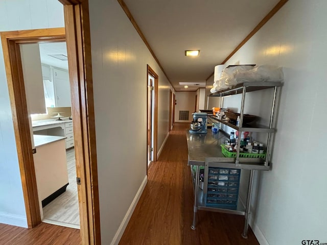 hallway with dark hardwood / wood-style flooring and crown molding