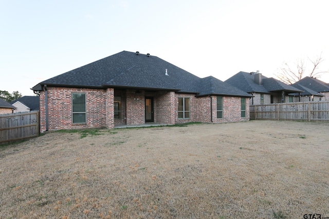 back of property featuring a patio and a yard