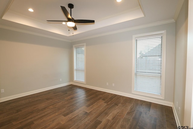 spare room with a raised ceiling, crown molding, dark wood-type flooring, and ceiling fan