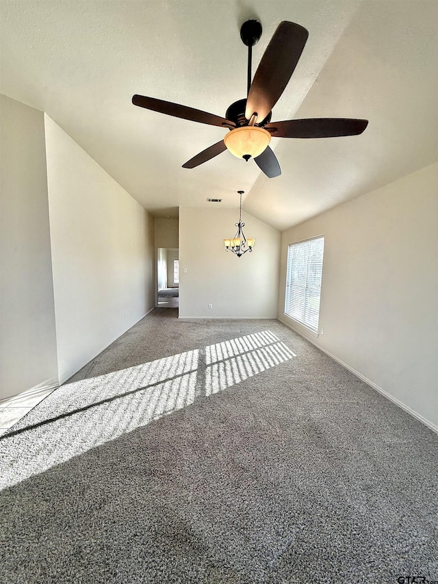 unfurnished living room with vaulted ceiling, carpet flooring, and ceiling fan with notable chandelier