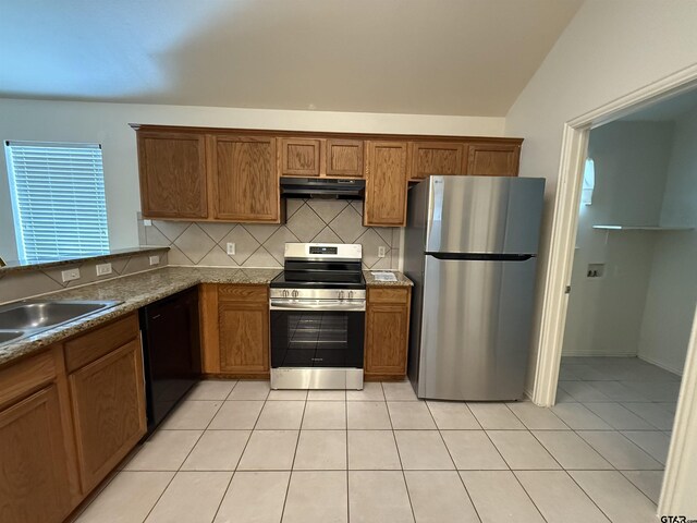 kitchen with vaulted ceiling, light tile patterned flooring, dishwasher, sink, and decorative backsplash