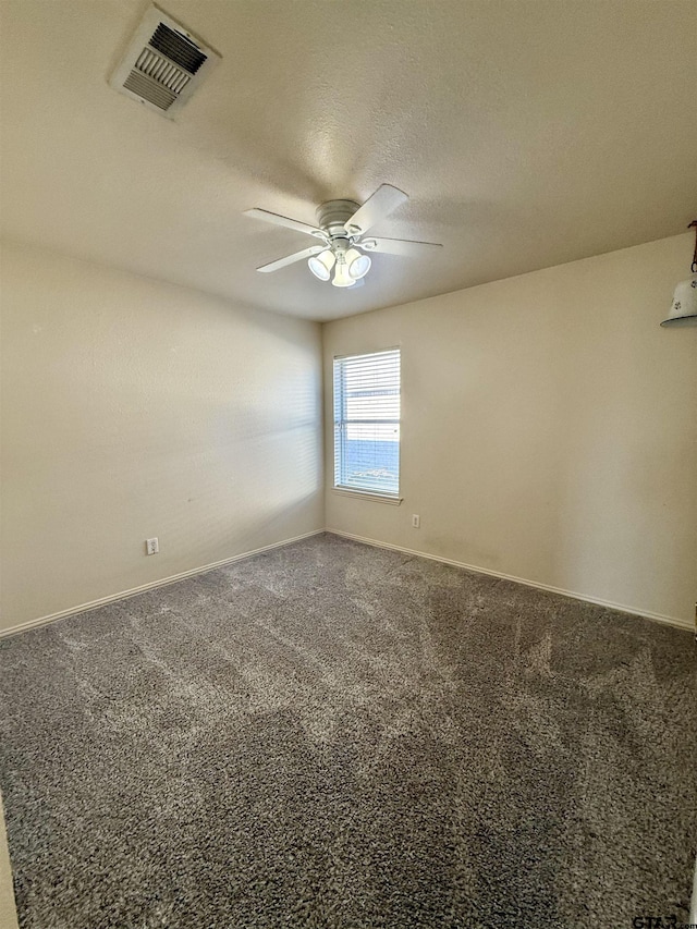 spare room with ceiling fan, a textured ceiling, carpet flooring, visible vents, and baseboards