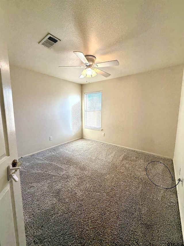 unfurnished room with carpet, visible vents, ceiling fan, a textured ceiling, and baseboards