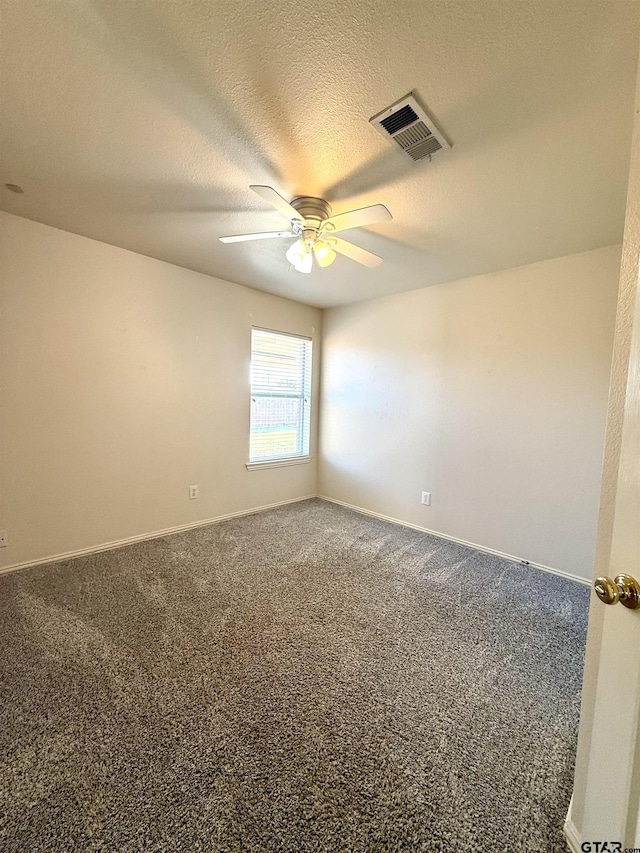 carpeted spare room with baseboards, visible vents, ceiling fan, and a textured ceiling