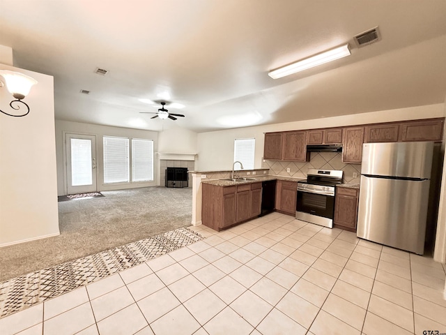 kitchen with light colored carpet, appliances with stainless steel finishes, open floor plan, a sink, and under cabinet range hood