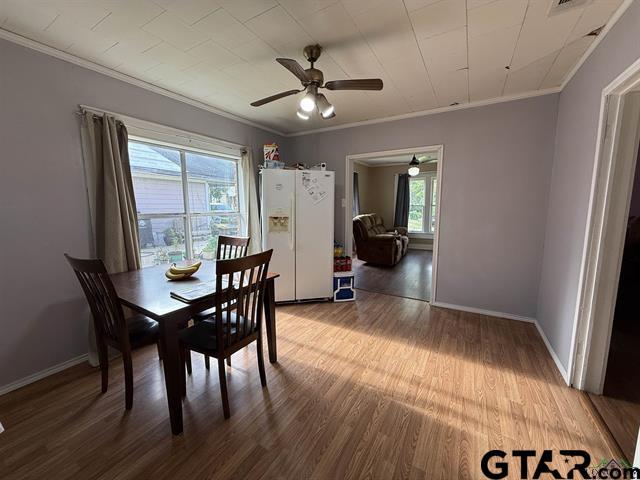 dining space featuring crown molding, plenty of natural light, wood finished floors, and ceiling fan