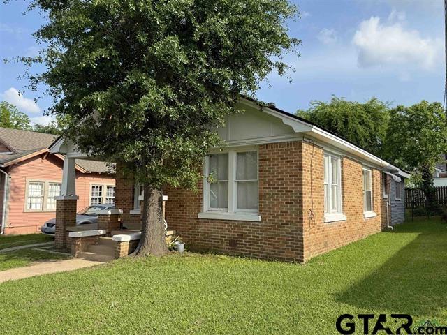 view of home's exterior featuring brick siding and a lawn