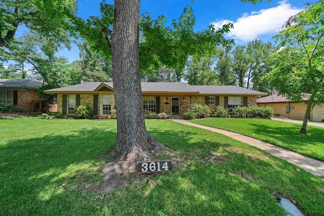 ranch-style home with brick siding and a front yard