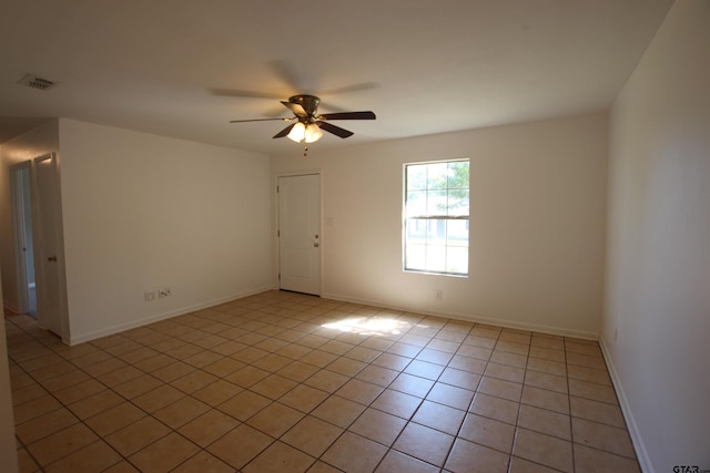 tiled empty room featuring ceiling fan