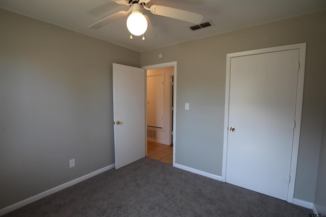 unfurnished bedroom with light colored carpet, ceiling fan, and a closet