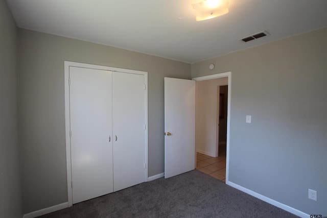 unfurnished bedroom featuring a closet and dark colored carpet