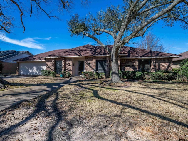 view of front of home featuring a garage, brick siding, driveway, and a front lawn