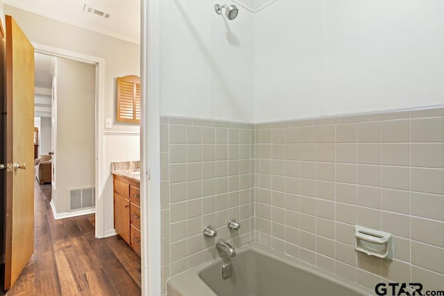10516 Debbie Ln, Flint, TX 75762 - bathroom featuring vanity, wood finished floors,  shower combination, ornamental molding, and a wainscoted wall