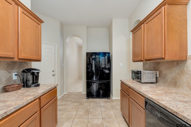 5821 Thompson Pl, Tyler, TX 75707 - kitchen featuring black appliances, tasteful backsplash, arched walkways, and light tile patterned flooring