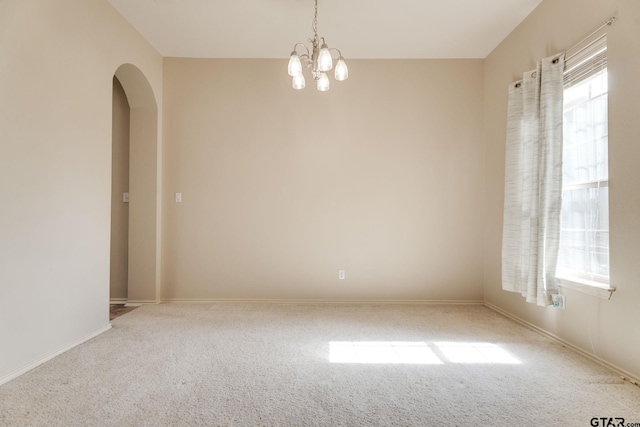 5821 Thompson Pl, Tyler, TX 75707 - empty room featuring carpet, a chandelier, and arched walkways