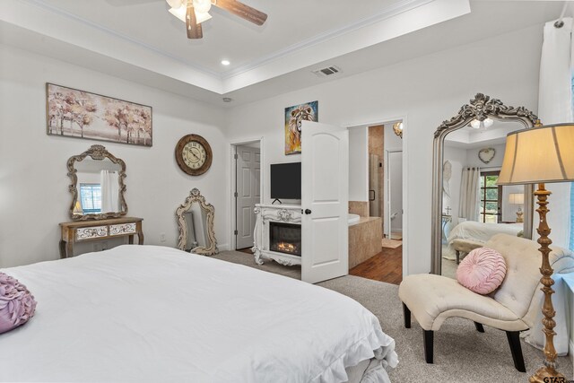 bedroom featuring ornamental molding, multiple windows, a raised ceiling, and visible vents