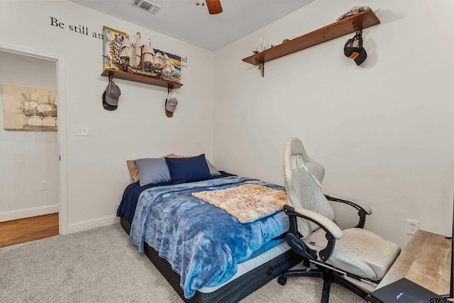 carpeted bedroom featuring baseboards, visible vents, and a ceiling fan