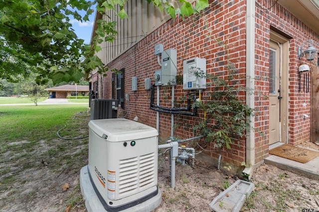 view of side of property featuring a yard, central AC, and brick siding