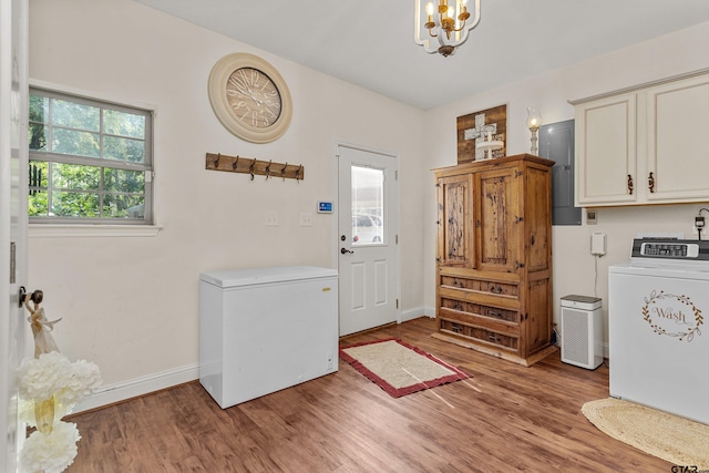 interior space with washer / dryer, a chandelier, light wood-style flooring, and baseboards