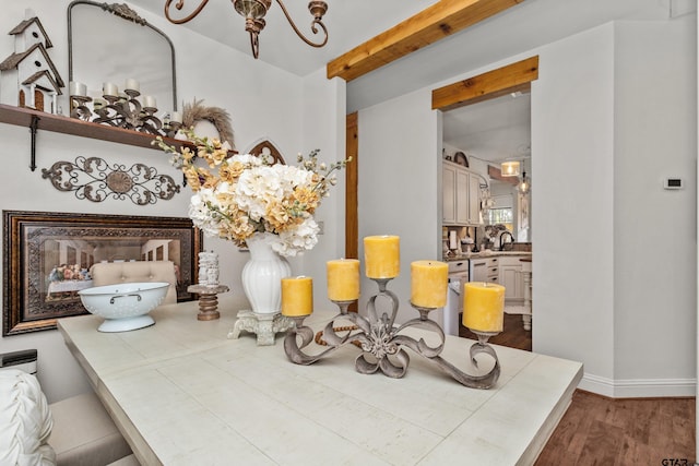 interior space with beam ceiling, baseboards, and wood finished floors