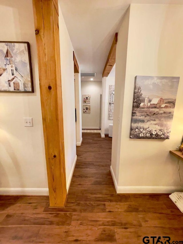 corridor featuring visible vents, baseboards, and wood finished floors