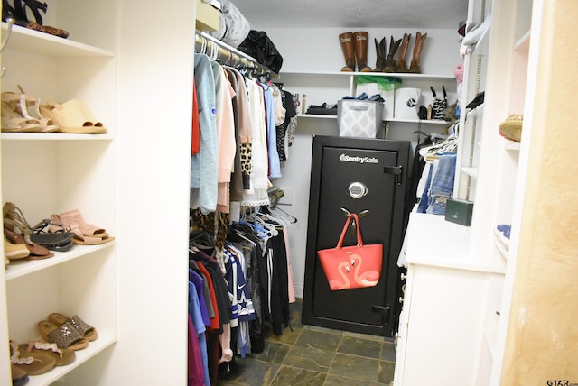 spacious closet featuring stone finish floor