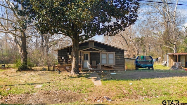 view of front of property with a front lawn and an outdoor structure