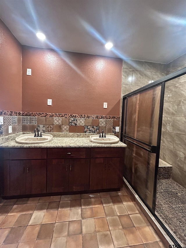 bathroom with vanity, backsplash, and a shower with shower door