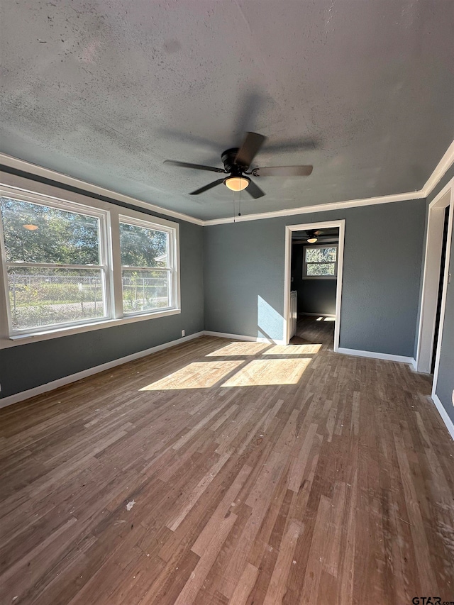 unfurnished bedroom with hardwood / wood-style flooring, ceiling fan, ornamental molding, and a textured ceiling