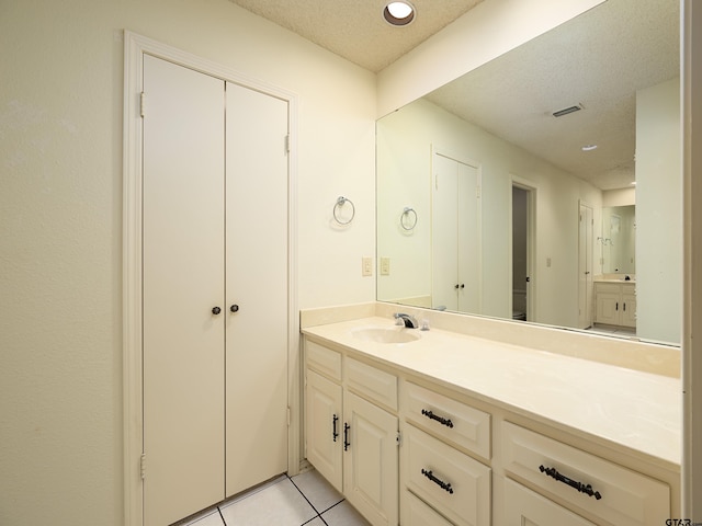 bathroom featuring tile patterned flooring, a textured ceiling, and vanity