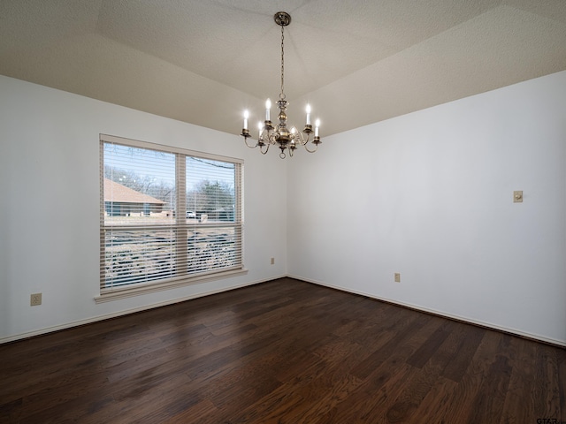 spare room with a chandelier, lofted ceiling, and dark wood finished floors