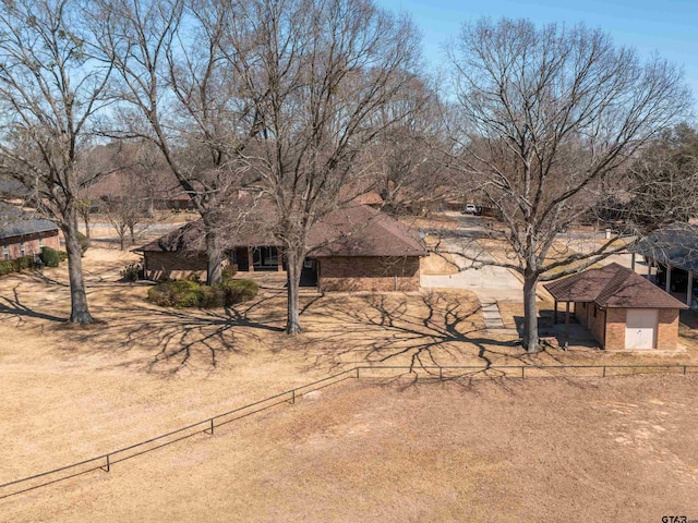 view of front of house featuring brick siding and fence