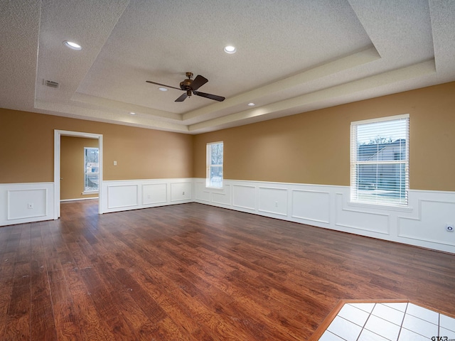 unfurnished room featuring a raised ceiling, visible vents, and a textured ceiling