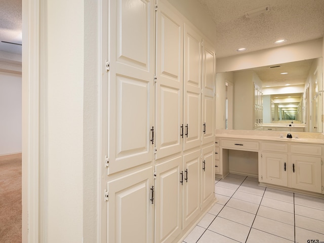 bathroom with a textured ceiling, tile patterned flooring, vanity, and recessed lighting